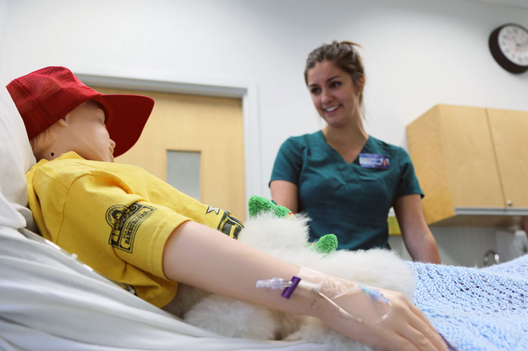 Static image of one undergraduate nursing student working on a simulation mannequin