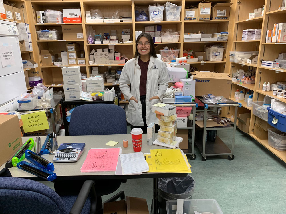 An undergraduate nurse in a lab coat in the simulation lab.