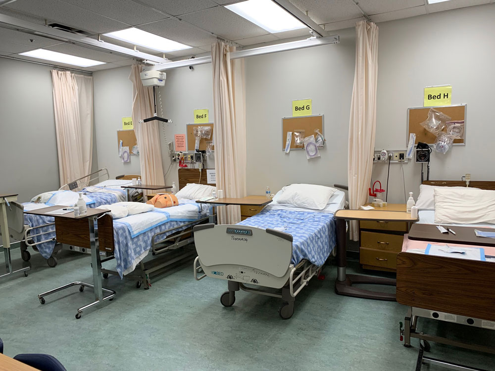 A group of hospital beds in a UBCO nursing simulation lab.
