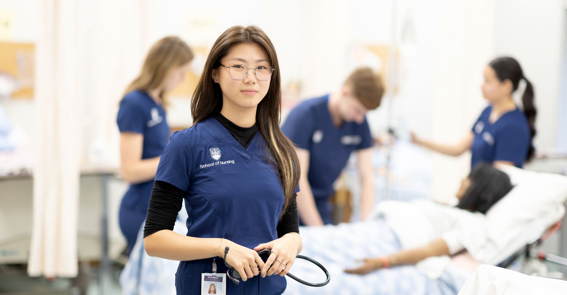 Nursing student holding stethoscope in front of other students