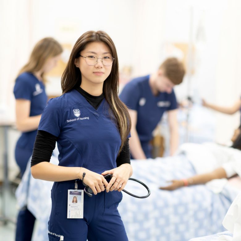 Nursing student holding stethoscope in simulation lab